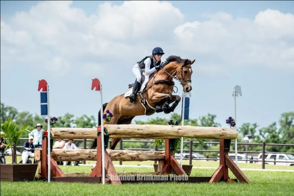 Alyssa Phillips riding Oskar over a log oxer on the cross-country course at The Event at TerraNova. Photo by Shannon Brinkman.