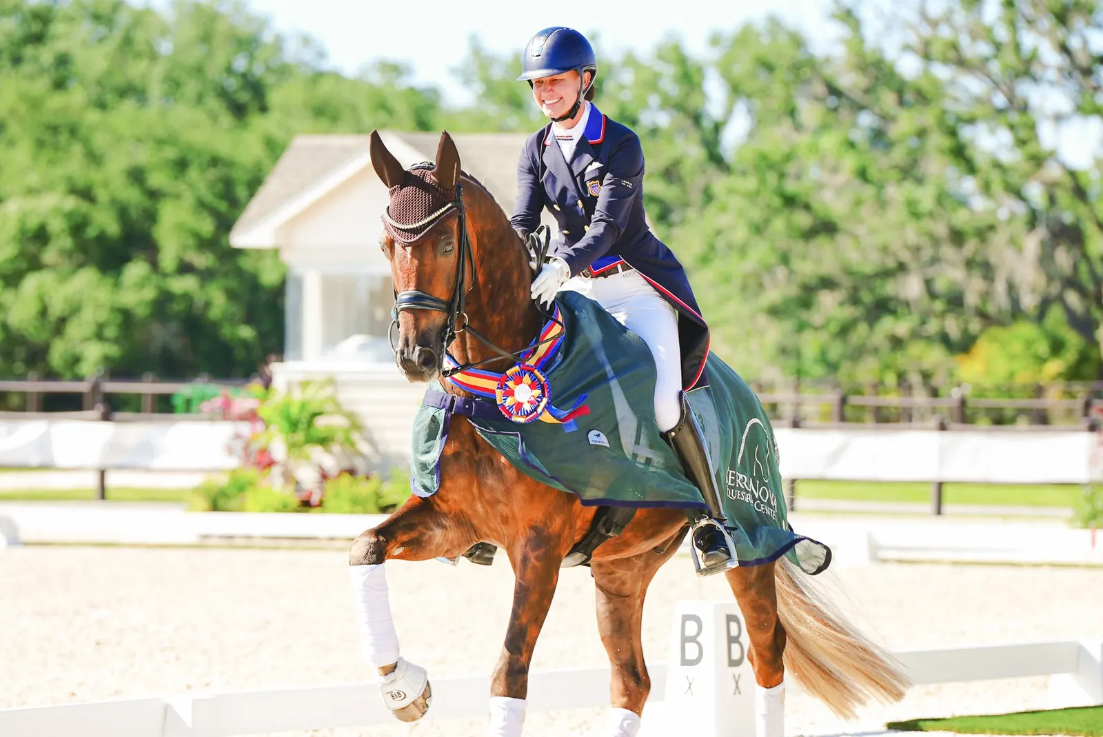 A winning dressage rider and horse wearing championship ribbons and an awards cooler at Dressage at TerraNova