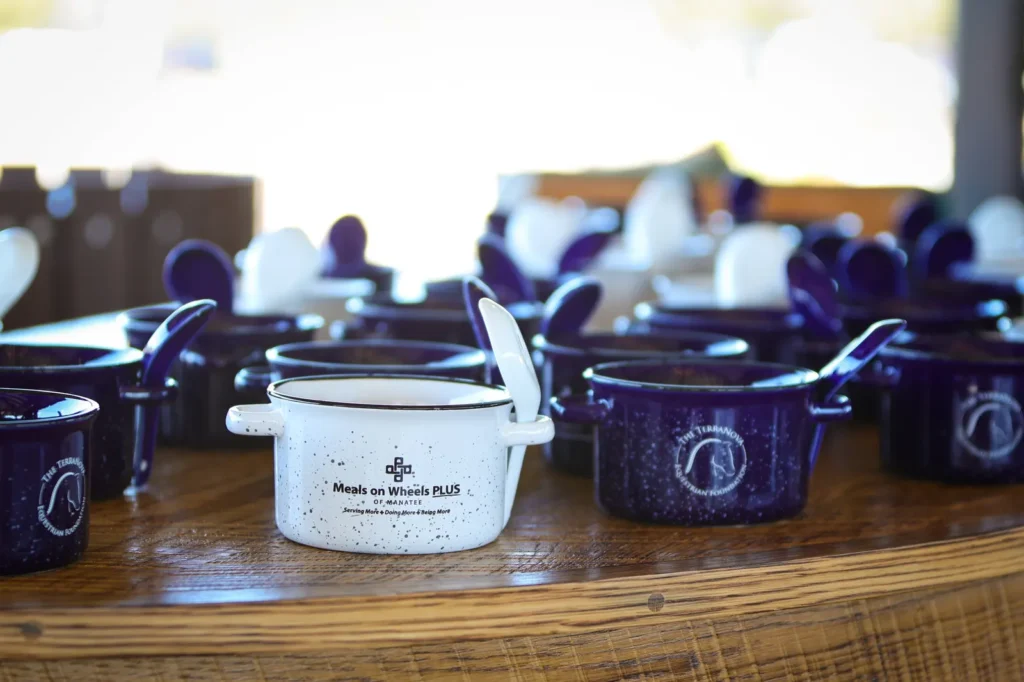 Handcrafted Empty Bowls soup mugs from Meals on Wheels PLUS of Manatee lined up on a table at TerraNova. Photo by EQ Media.