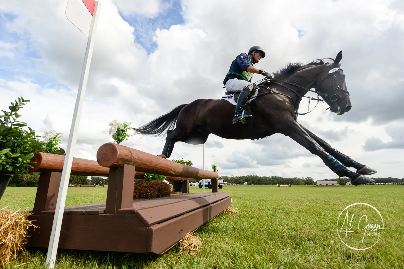Kyle Carter and a dark horse jumping a cross-country fence on the eventing course at TerraNova Equestrian Center. Photo by Al Green.