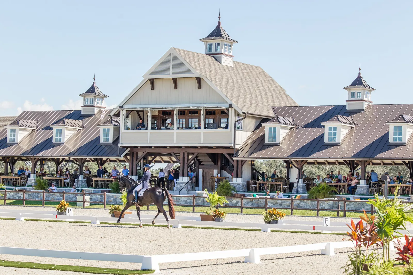 Dressage horse and rider performing in front of the grand pavilion filled with spectators at TerraNova Equestrian Center. Photo by EQ Media.