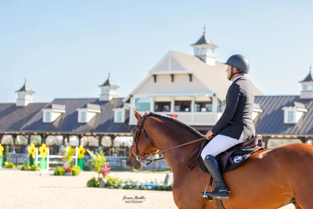 Horse and rider entering the show jumping arena in front of the pavilion at TerraNova Equestrian Center. Photo by Jessica Buehler Photography.
